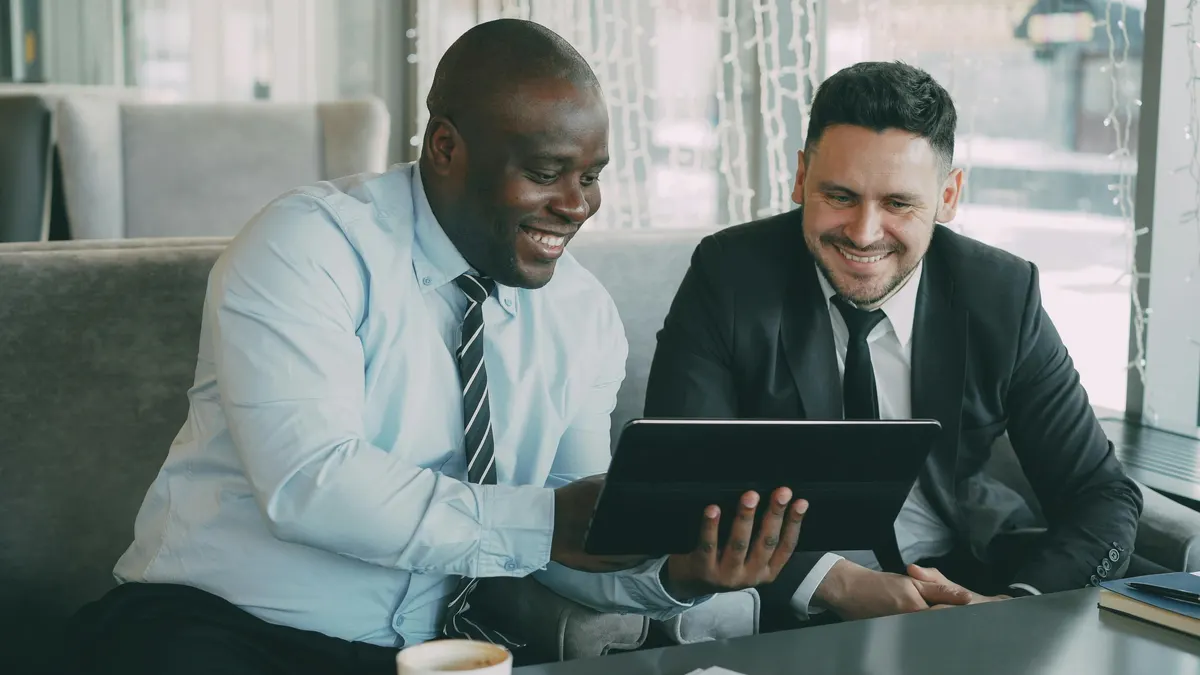 Illustrative photograph of two people reviewing a workflow on a tablet