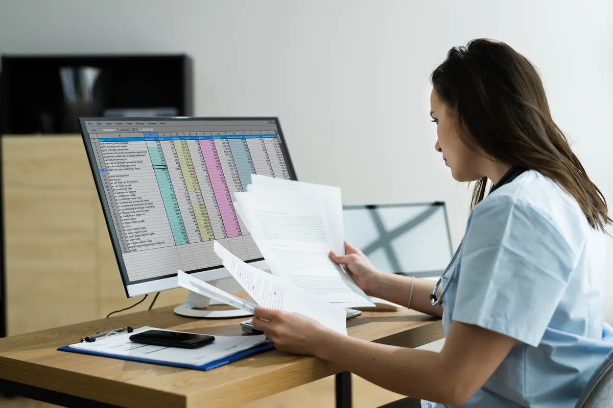 Illustrative photograph: a healthcare professional reviewing operational records
