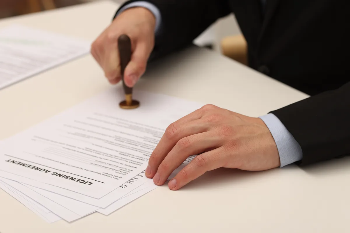 Illustrative photograph: a licensing agreement being reviewed