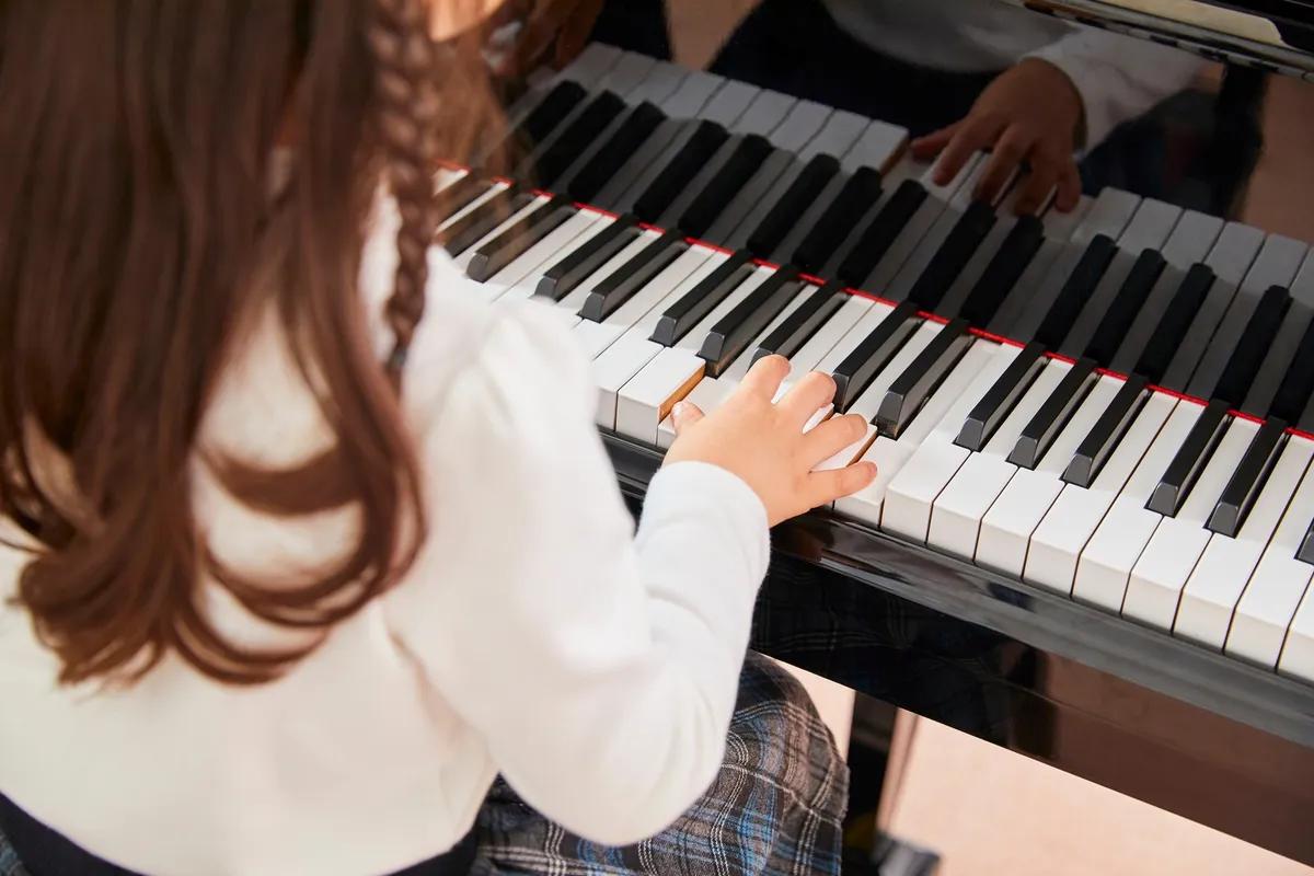 Illustrative photograph: hands playing a piano